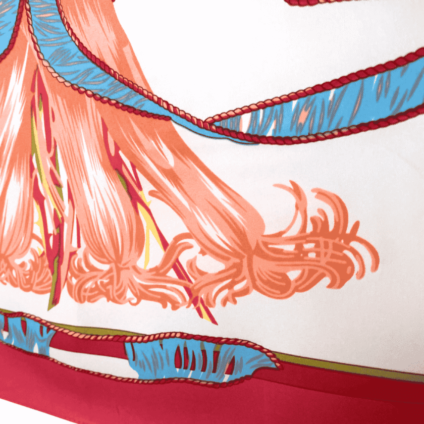 Cadeau en soie femme – détail foulard fleuri vintage, ruban bleu à liseré tressé et franges corail sur fond ivoire, bordure fuchsia