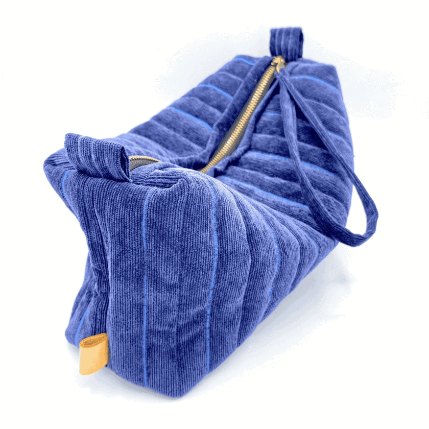 Profil et base de la Rec Baie — trousse de toilette fait main velours côtelé bleu chambray matelassé, structure souple, étiquette cuir moutarde
